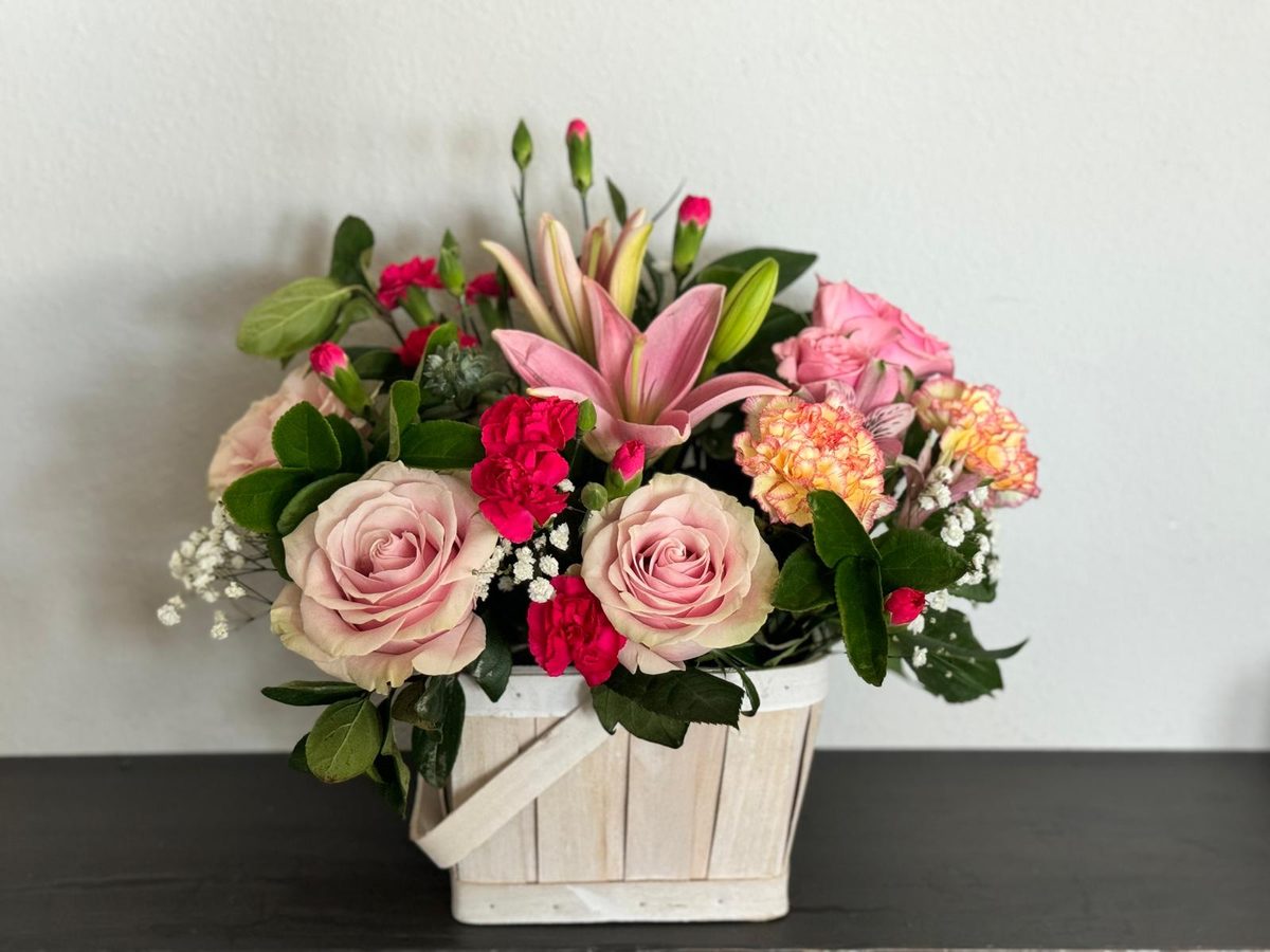 Arreglo de rosas, lilium y claveles en canasta blanca de Elements Florist